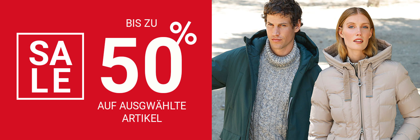Werbung für einen Ausverkauf mit bis zu 50 % Rabatt auf ausgewählte Artikel, daneben stehen ein Mann und eine Frau in Winterjacken.