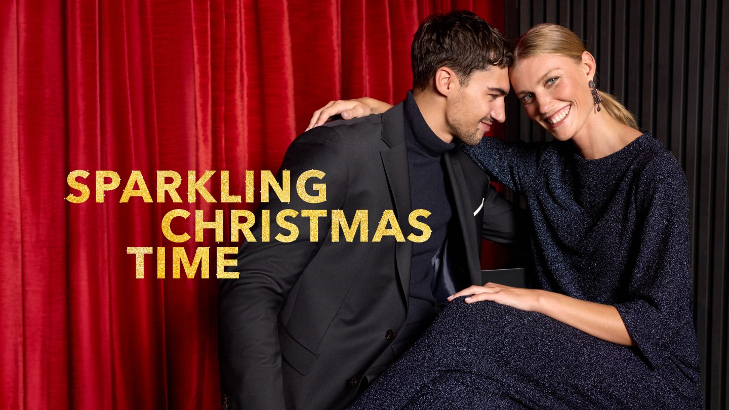 Egy elegáns pár együtt mosolyog vörös és fekete háttér előtt, miközben a kép bal oldalán az aranyló "Sparkling Christmas Time" felirat látható.